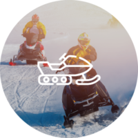 Two people riding snowmobiles